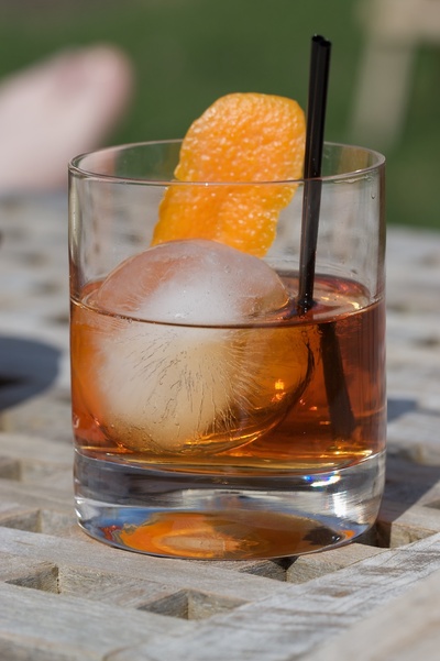 Round Spherical Ice Cube Ball In A Cocktail Glass With Unique Rim